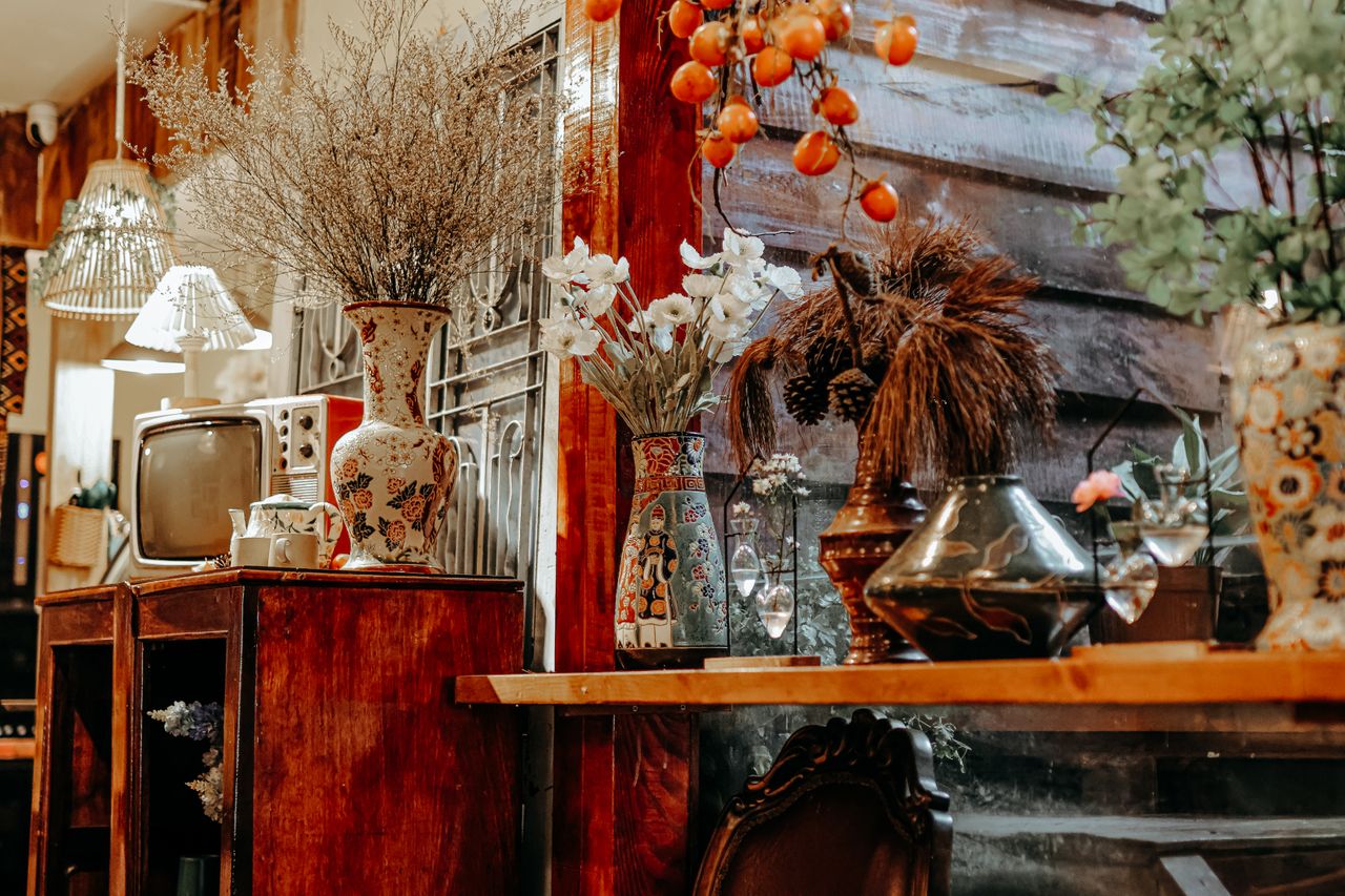 Cozy rustic interior featuring vintage decor, floral vases, and antique TV.