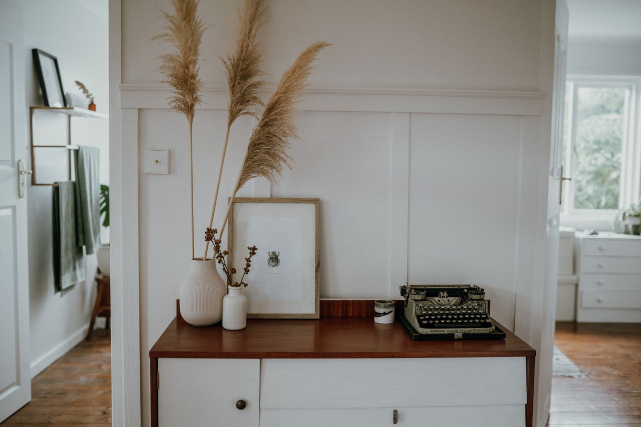 hero-img-02 Elegant Scandinavian interior with pampas grass and vintage typewriter decor.