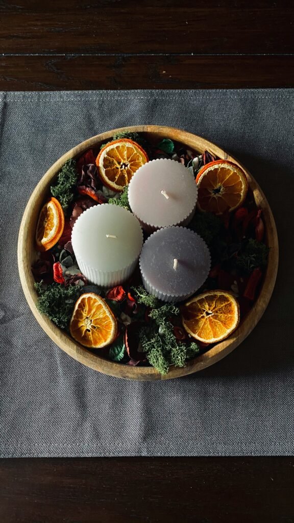 Christmas table centerpiece ideas, wooden bowl candle centerpiece with dried orange slices and dried flowers