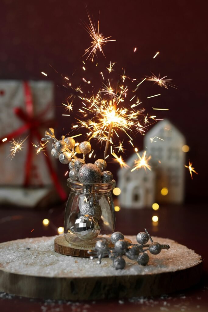 Christmas table centerpiece ideas, ornament-filled glass jar with sparkler on a wood slice
