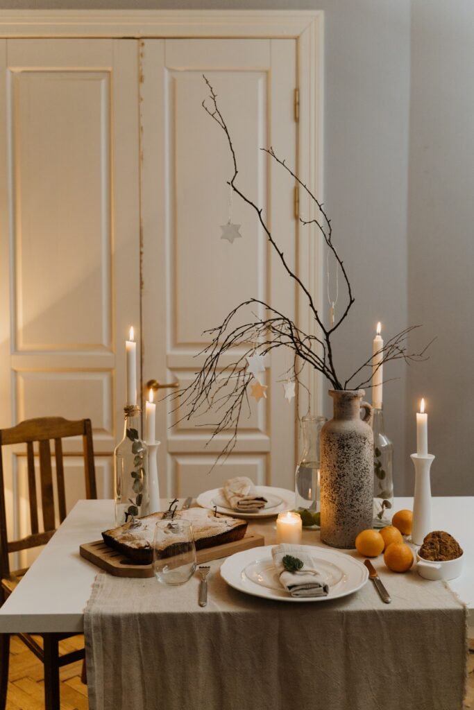 Christmas table centerpiece ideas, minimal small table setup with a branch vase and taper candles