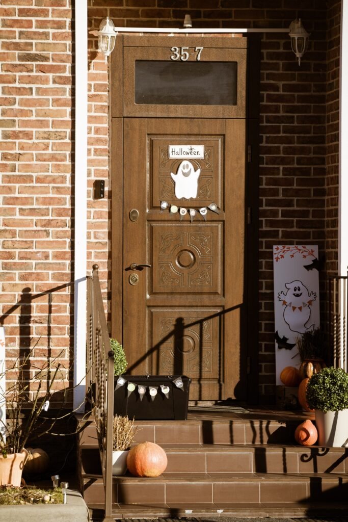 27 Stunning Halloween Door Decoration Ideas. Halloween door decoration idea for apartments with pumpkin and ghost garland