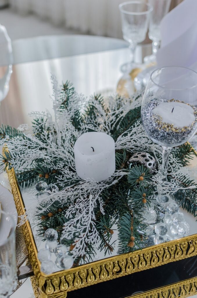 Christmas table centerpiece ideas, white pillar candle and frosted greenery on gold mirrored tray
