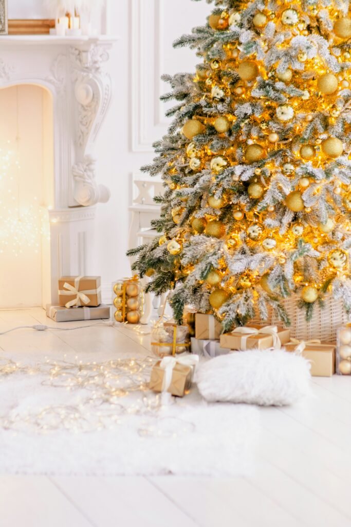 7.5 foot white Christmas tree with warm white lights and gold ornaments in a living room